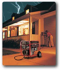 A person connects a portable generator to a house during a thunderstorm. The house is lit and lightning is visible in the sky.